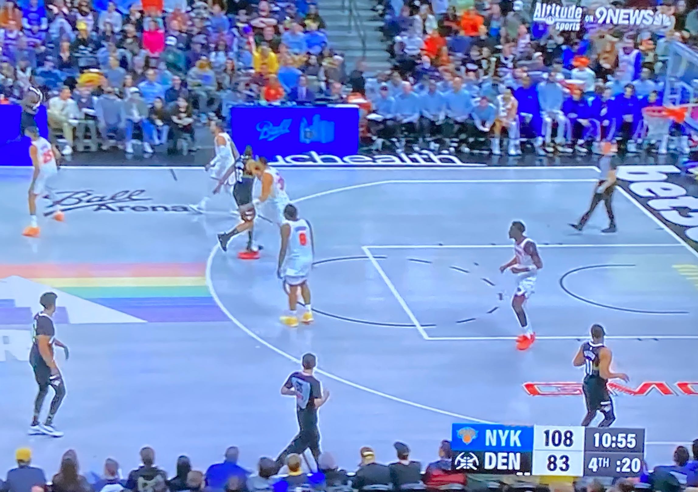 photo of a tv set showing a baseketball game between the nuggets and the nicks cropped to make the score bug prominent